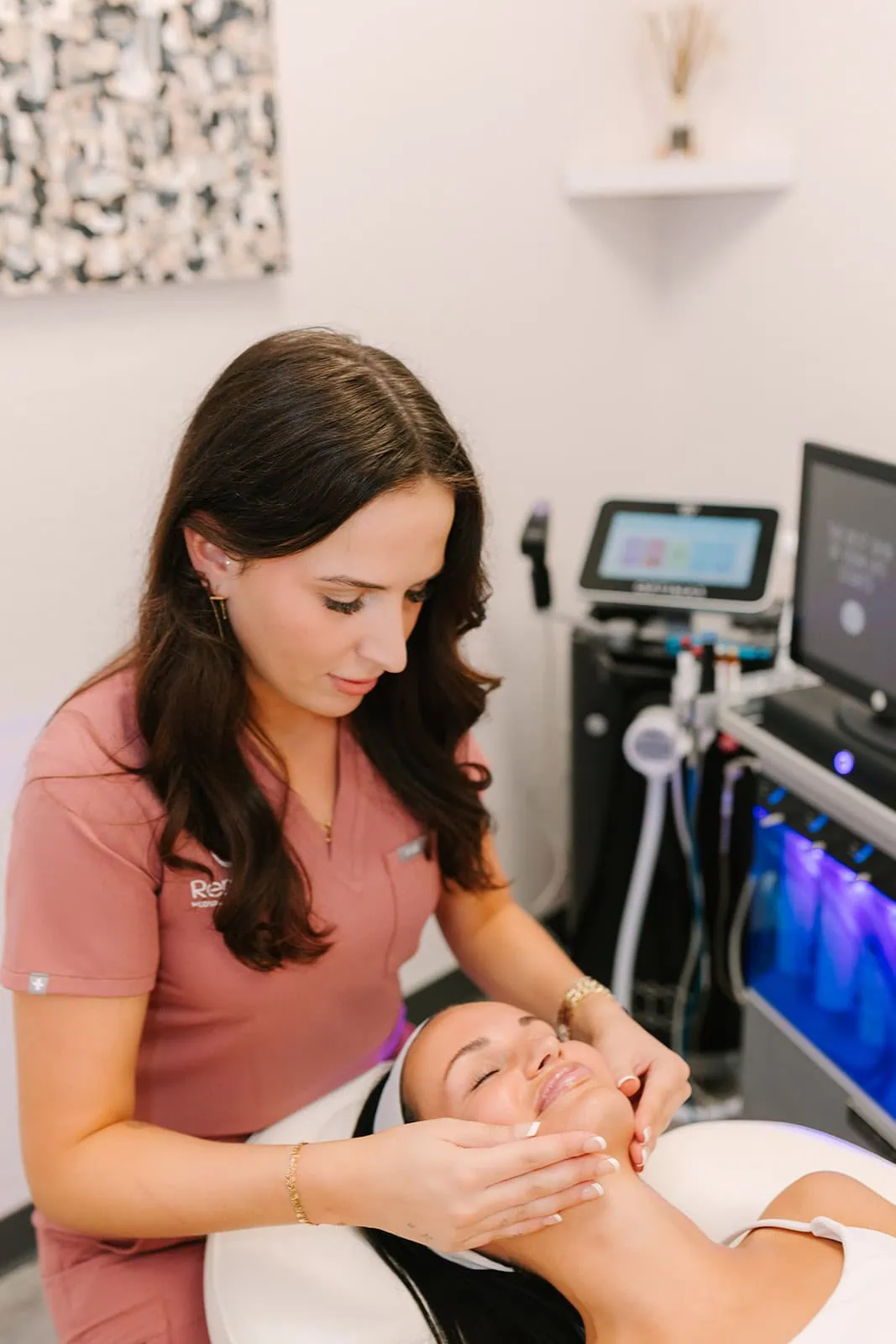 Aesthetician performing Kybella® treatment on a female client at RenuYou Aesthetics in Ames, IA